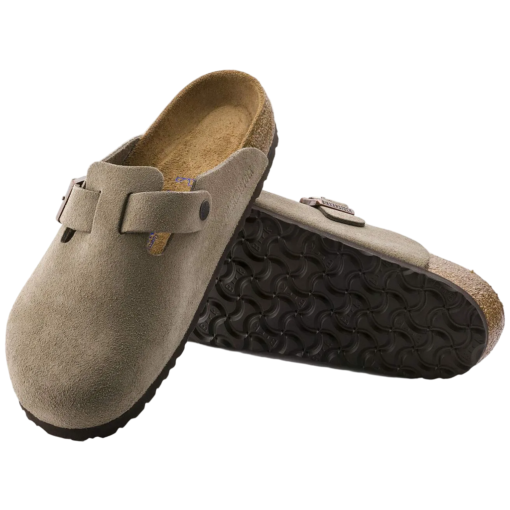 Pair of brown suede clogs with black soles on a white background