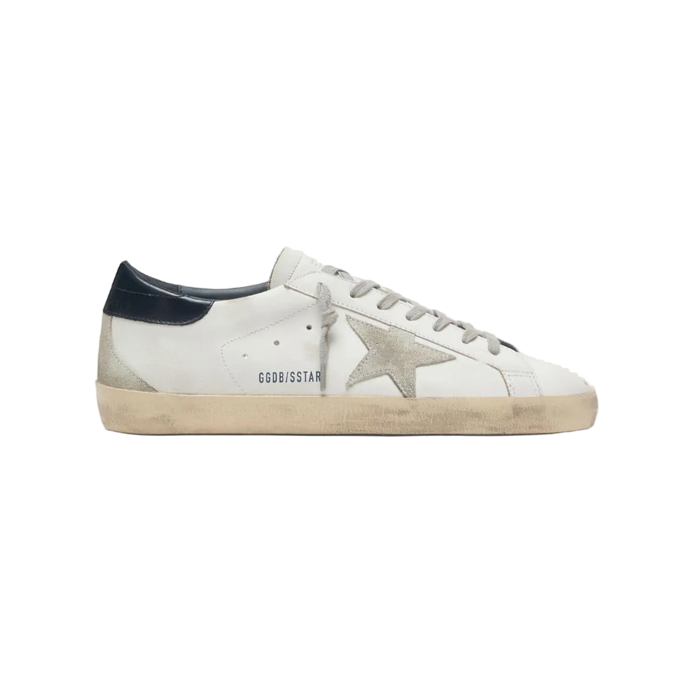 White sneaker with navy accents on a light beige background