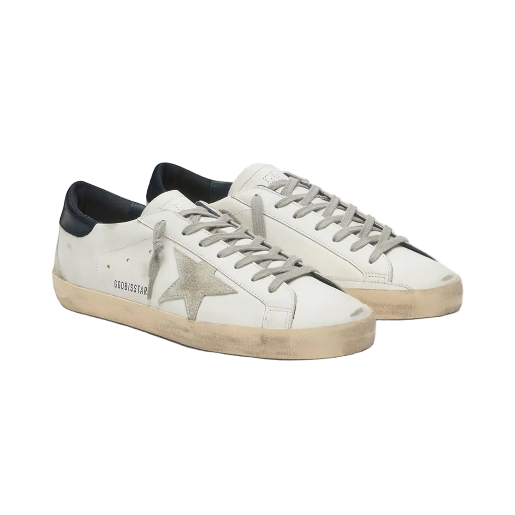White sneakers with black soles on a light gray background